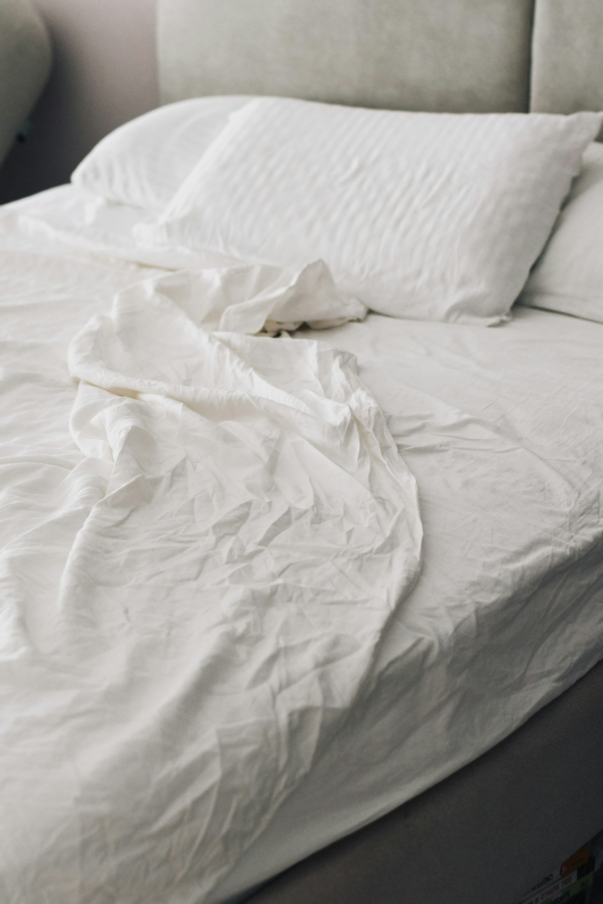 Lit blanc aux draps de coton froissés